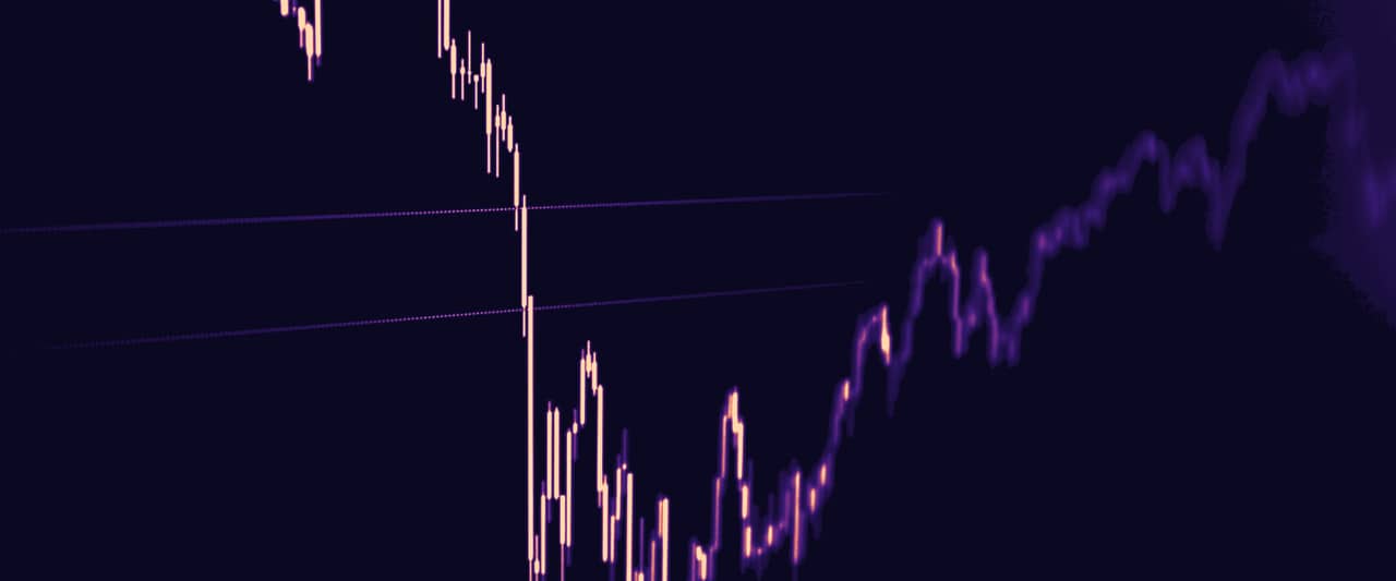Candele di prezzo che scendono e risalgono su un grafico scuro