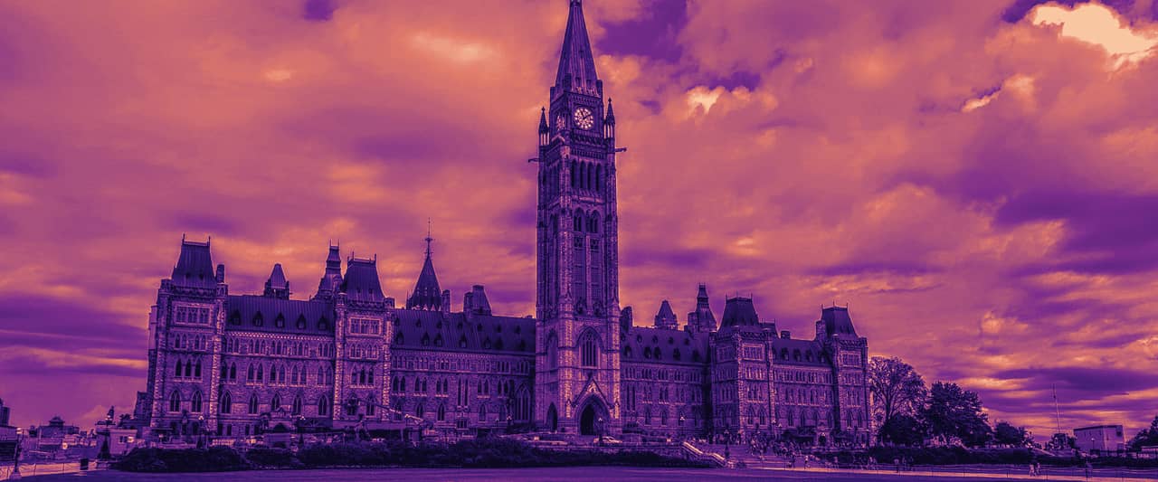 The Centre Block and Peace Tower on Parliament Hill in Ottawa under a cloudy sky