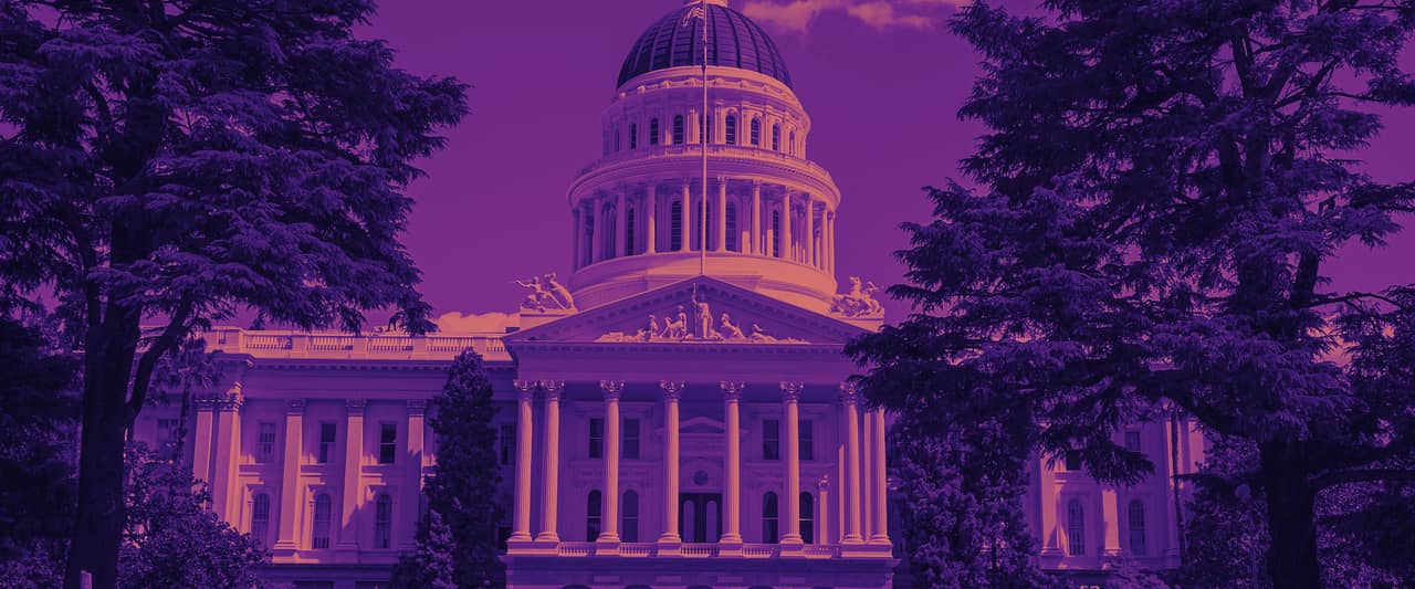 The domed California State Capitol in Sacramento framed by trees