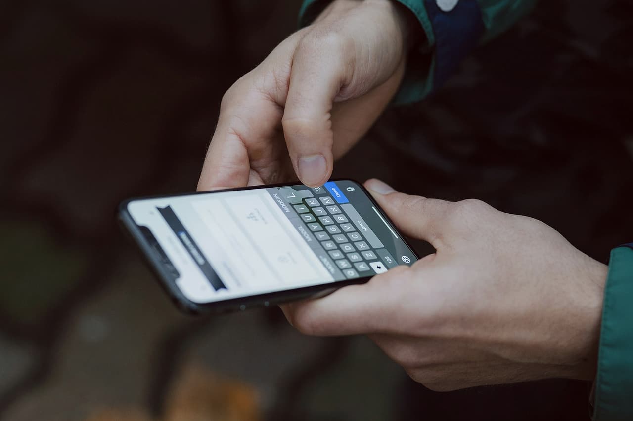 Two hands holding a smartphone and typing on it