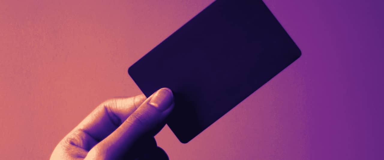 A hand holding a plain blue card against a white background