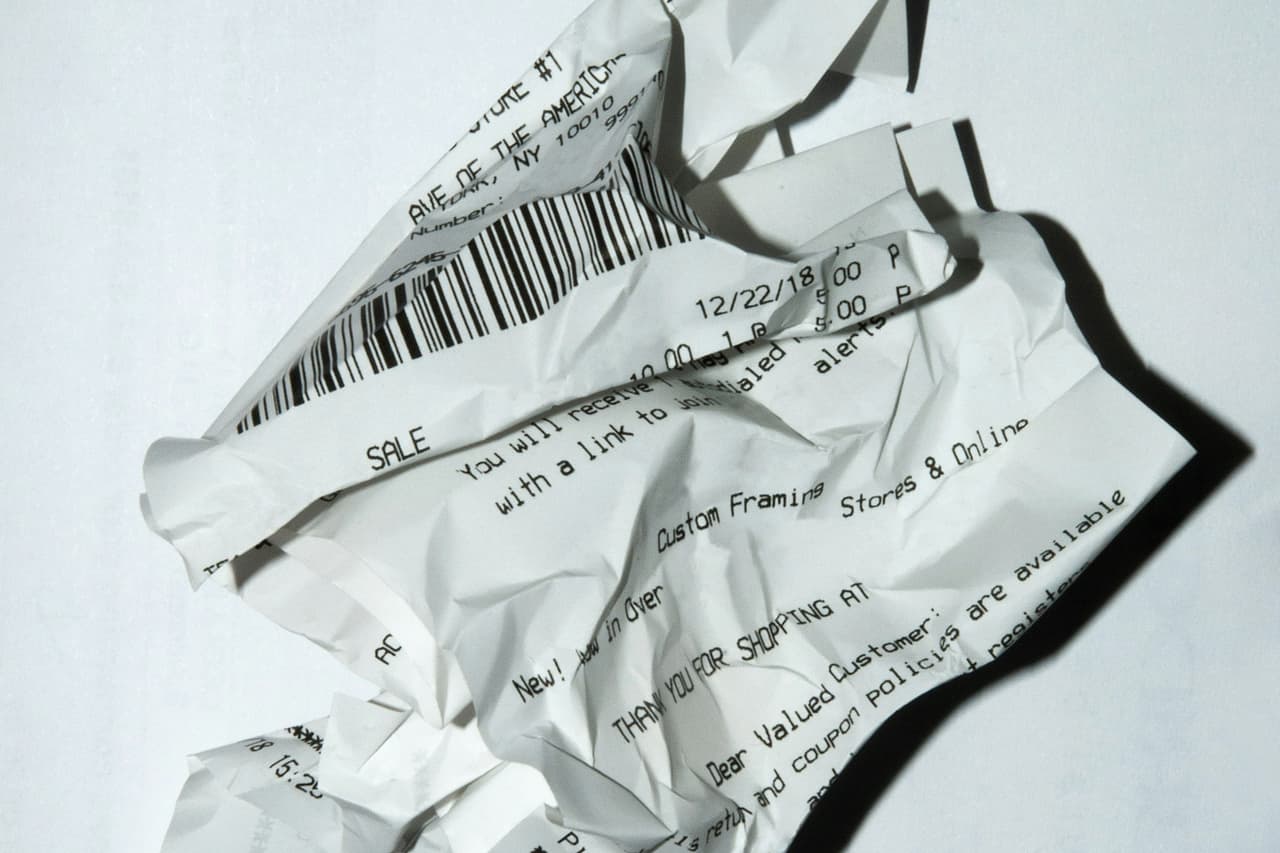 A crumpled paper receipt on a white surface
