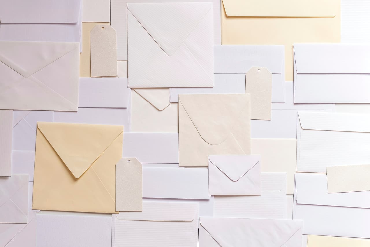 Cream and white paper envelopes spread across a table