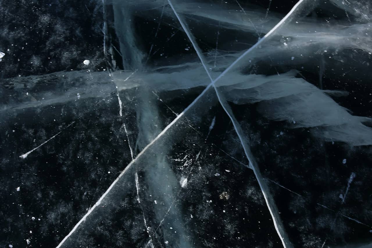 A sheet of cracked ice with blue lines running through it