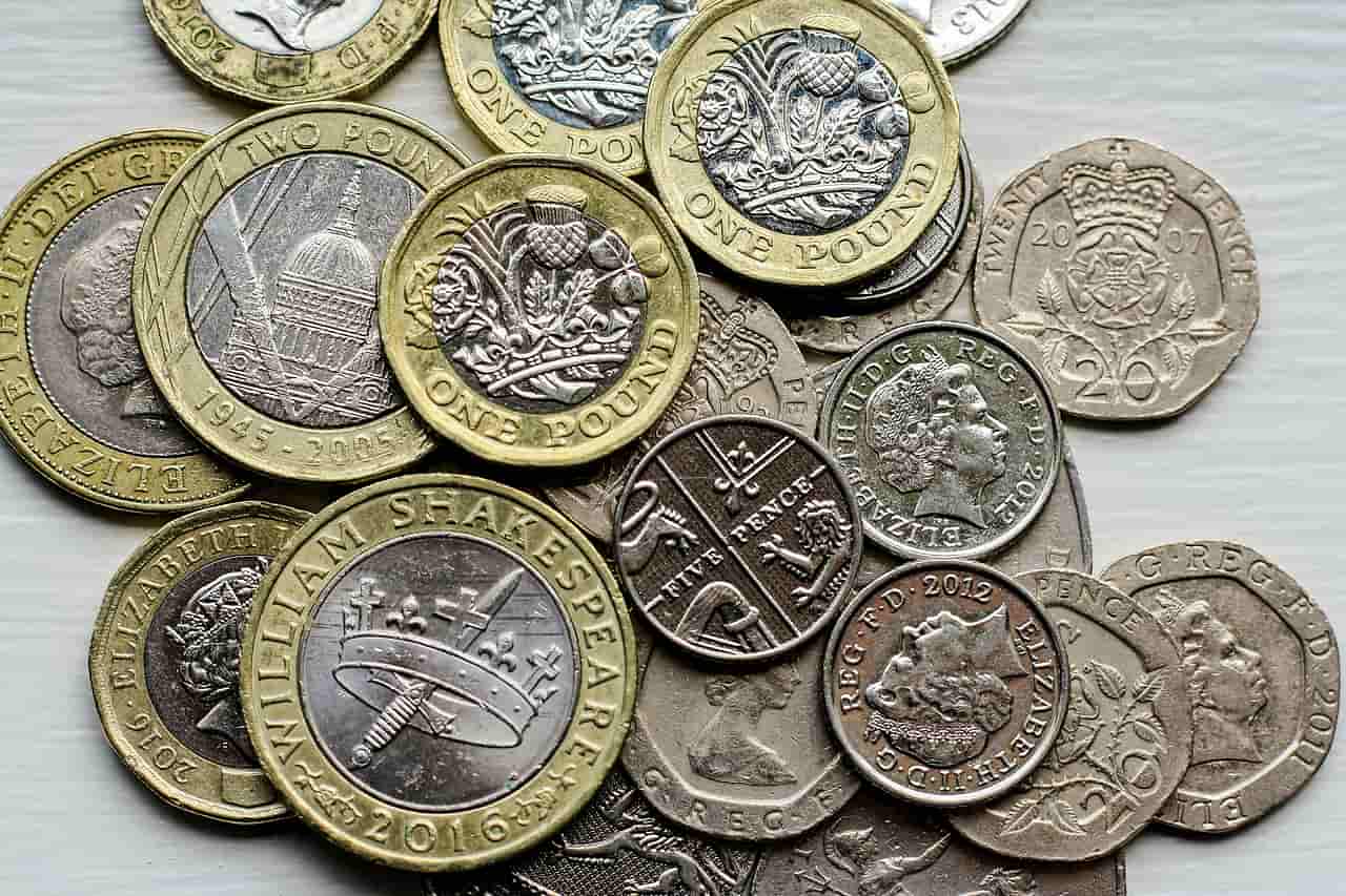A pile of British pound and penny coins on a table