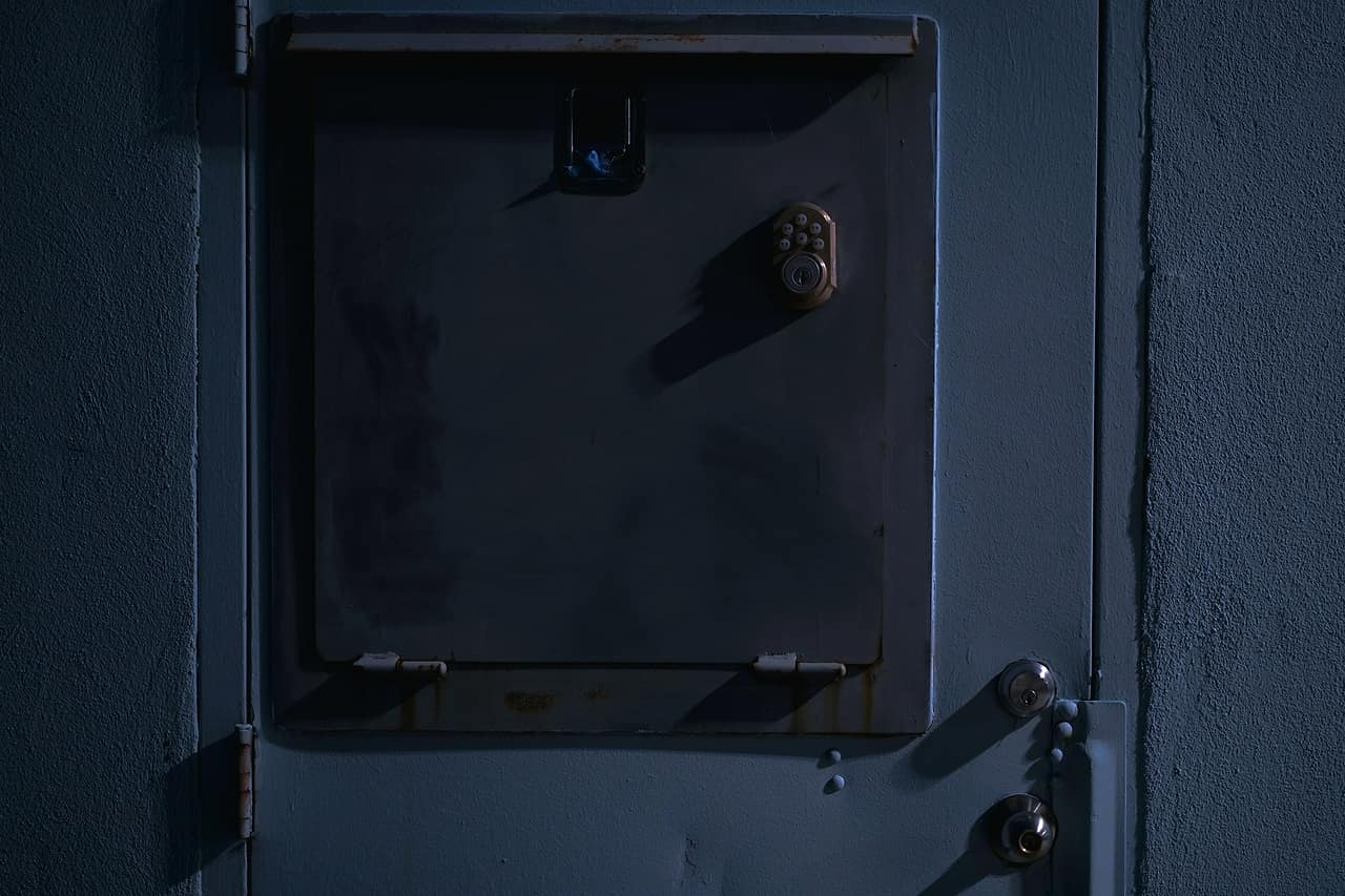 A closed blue metal door with a heavy lock