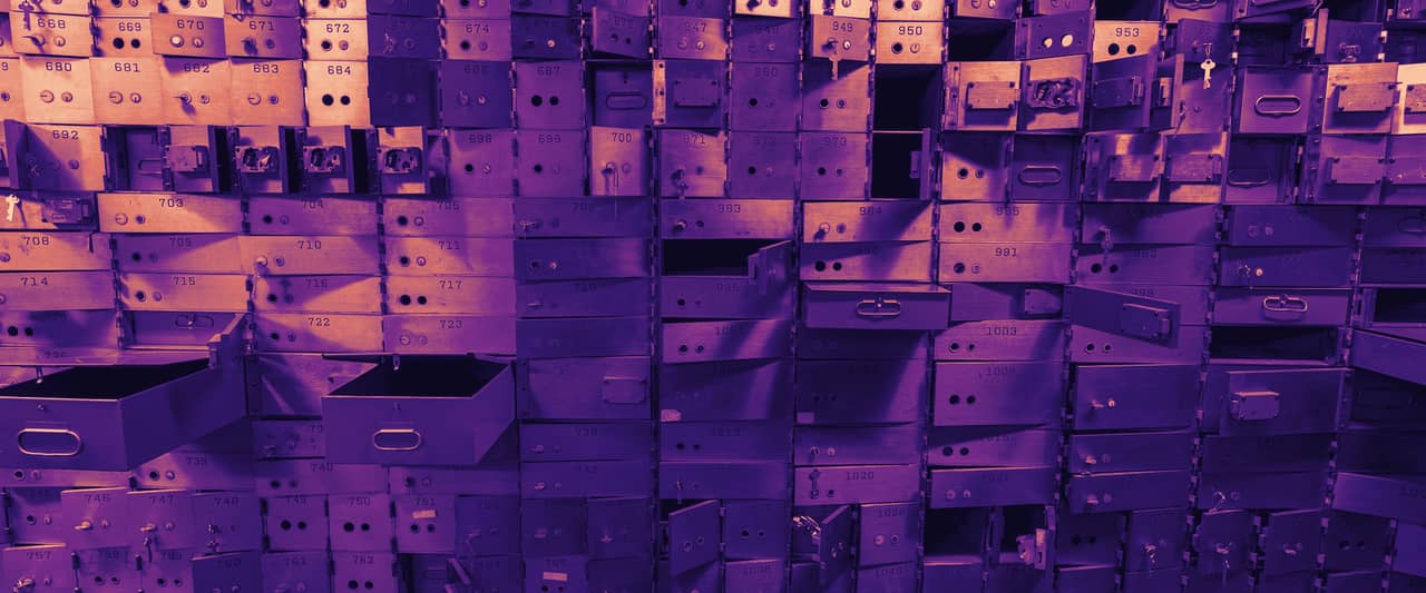 Stacks of empty metal safe deposit boxes in a bank vault