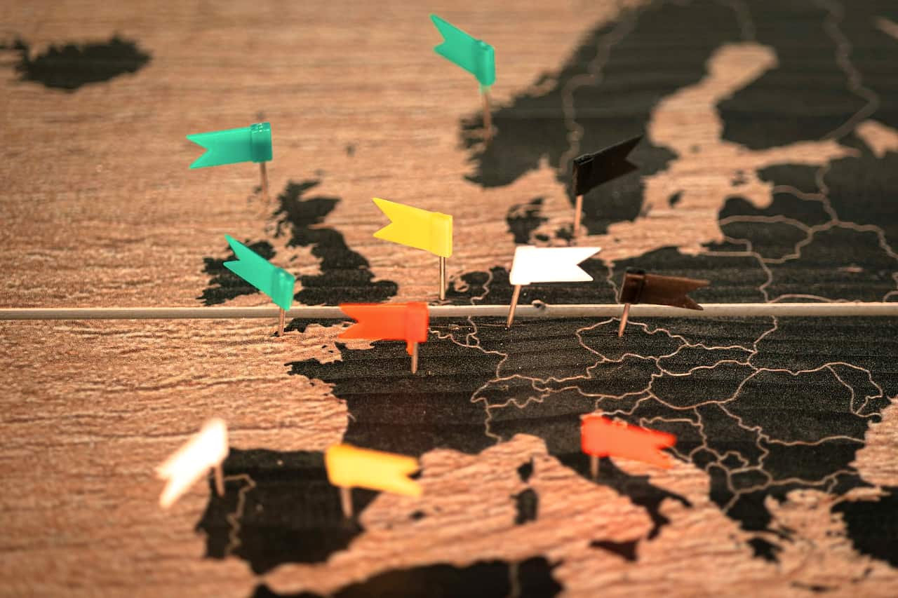 Coloured flag pins on a wooden map of Europe