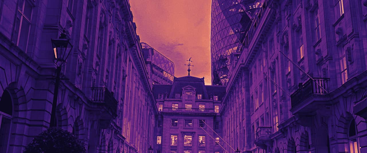 An empty street between stone office buildings in the City of London