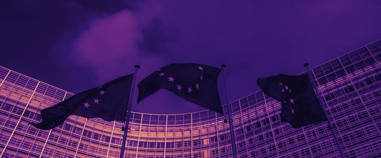 European Union flags flying outside a large curved office building