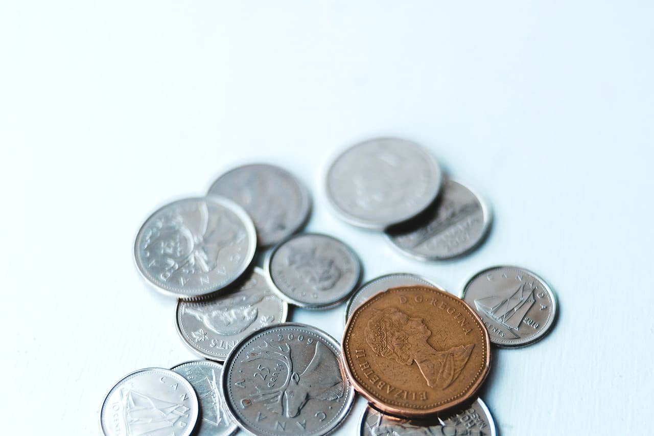 A few silver coins and one copper coin on a pale surface
