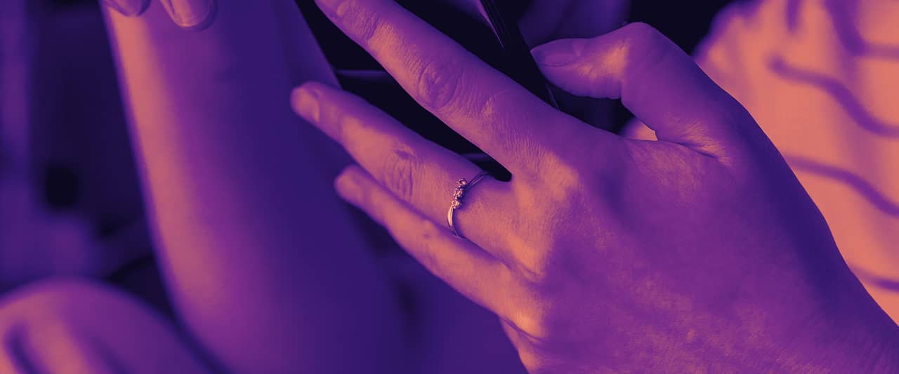 Two hands holding a smartphone, the screen out of view