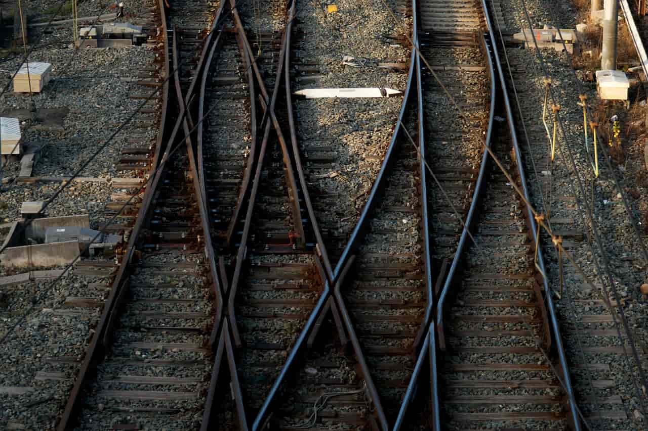 Railway tracks crossing and splitting at a junction under overhead wires