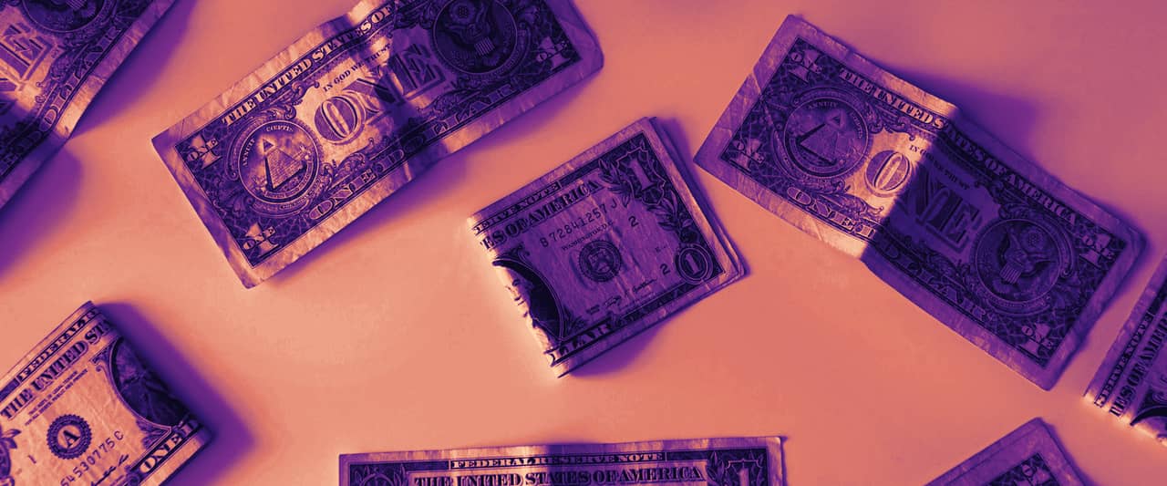 One dollar bills scattered across a white surface