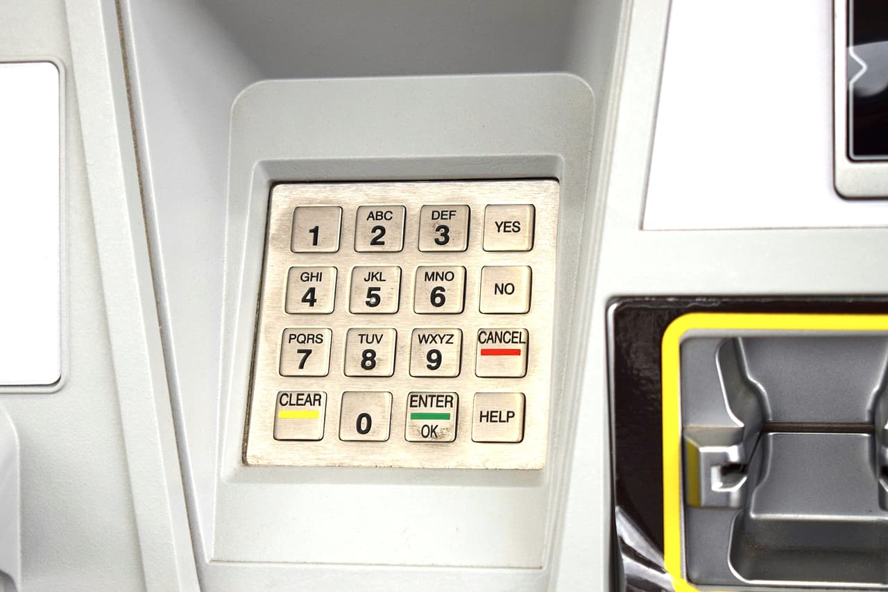 A worn numeric keypad and card slot on a self-service machine
