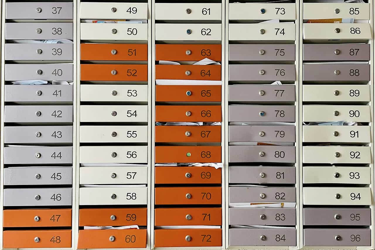 A wall of numbered metal mailboxes
