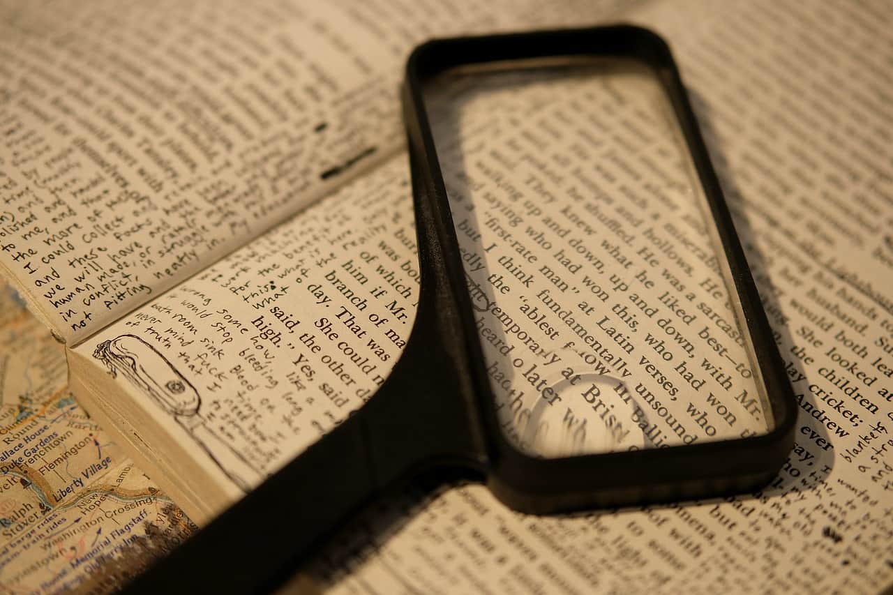 A rectangular magnifying glass held over the printed page of an open book