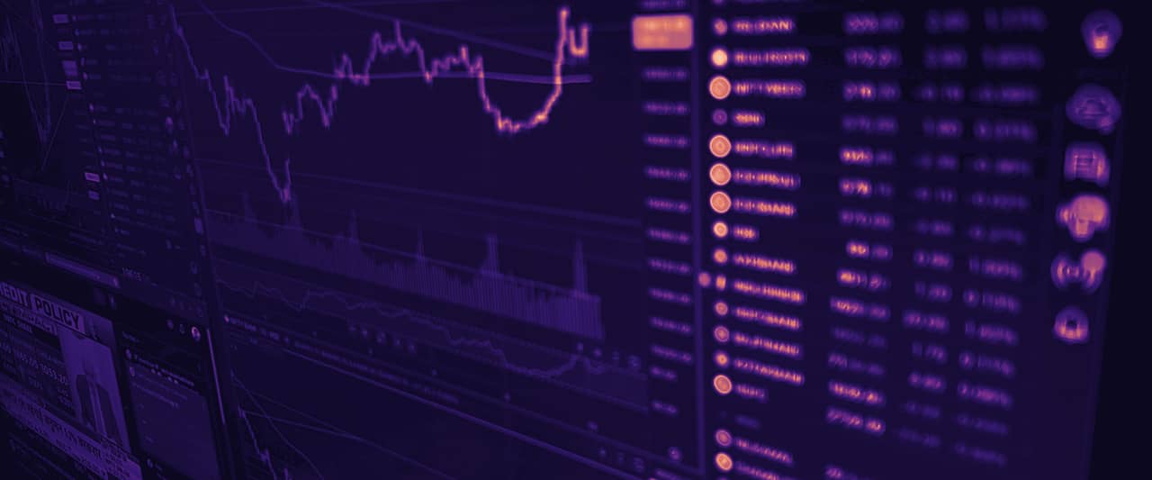 A monitor full of price charts and a scrolling list of quotes