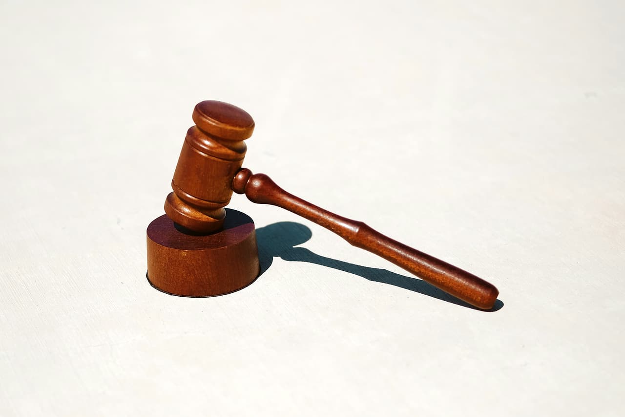 A wooden judge's gavel on a white surface