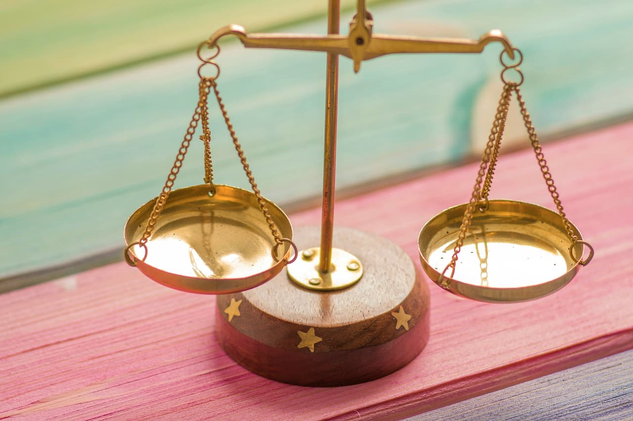 A small brass balance scale on painted wooden boards