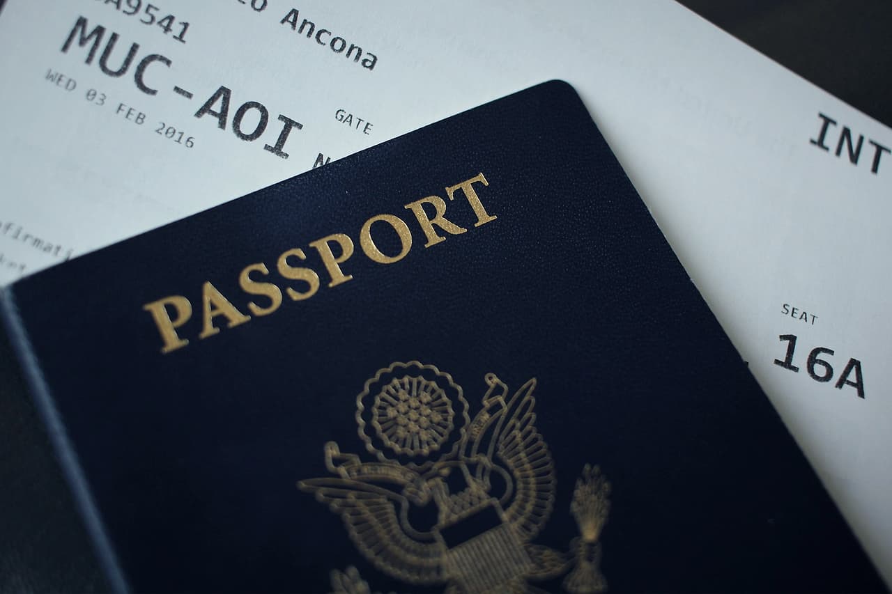 A US passport resting on an airline boarding pass