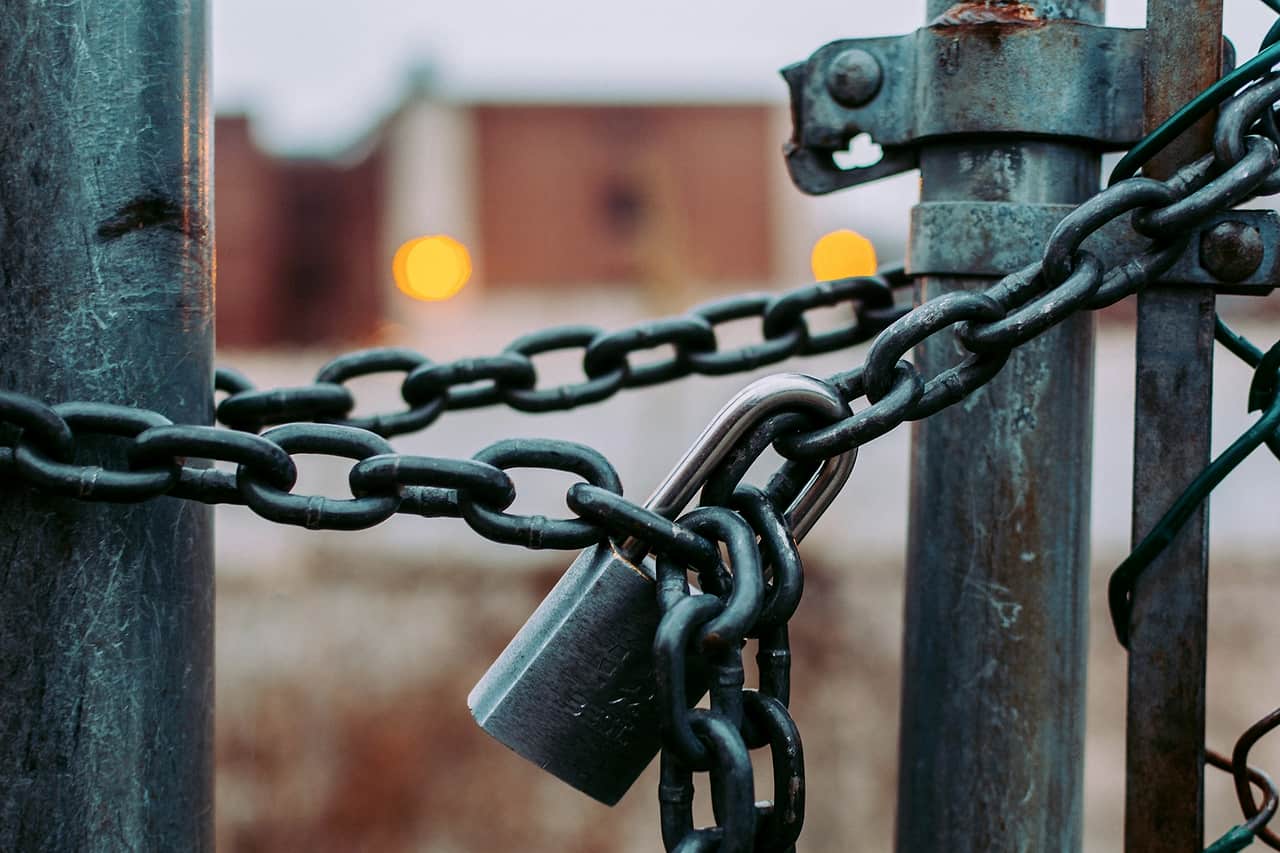 A padlock and chain closing a metal gate