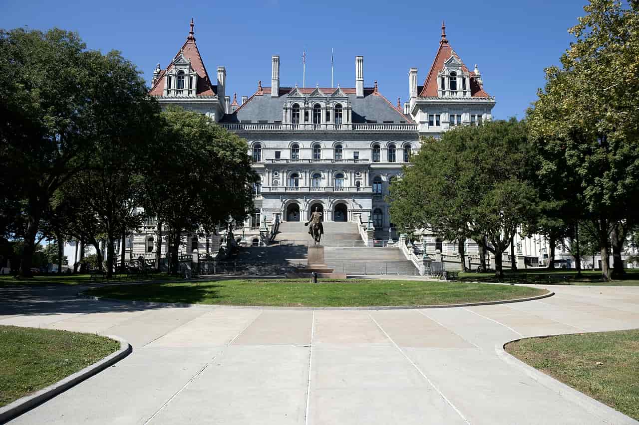 The New York State Capitol in Albany seen across a plaza lined with trees