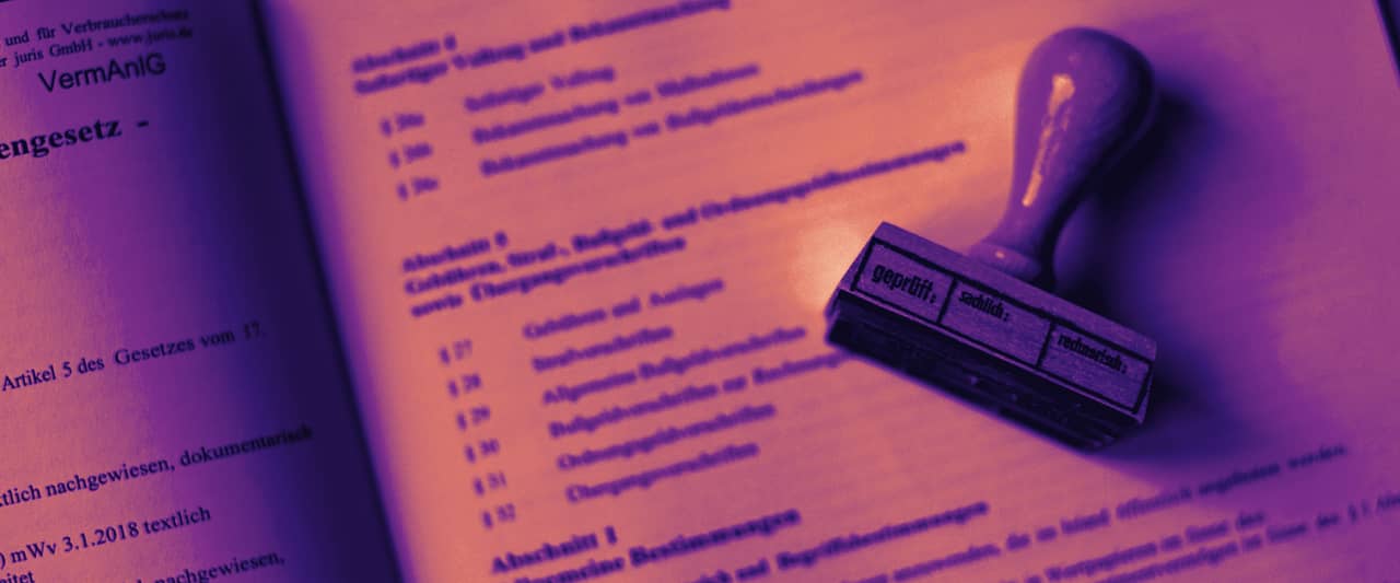 A wooden rubber stamp resting on an open printed document