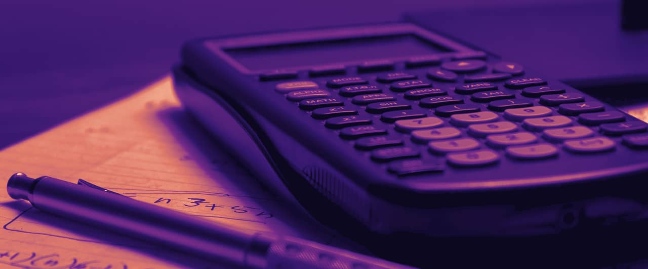 A calculator and a pen resting on printed figures