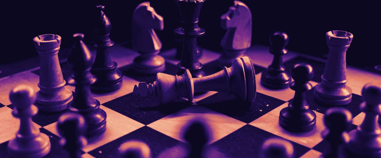 Black and white chess pieces in play on a checkered board