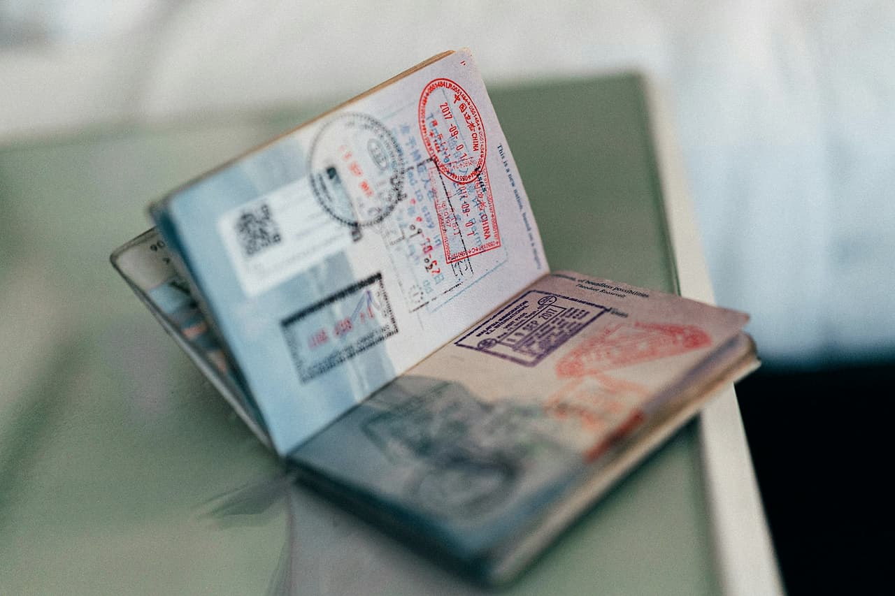 An open passport with colourful ink stamps on its pages