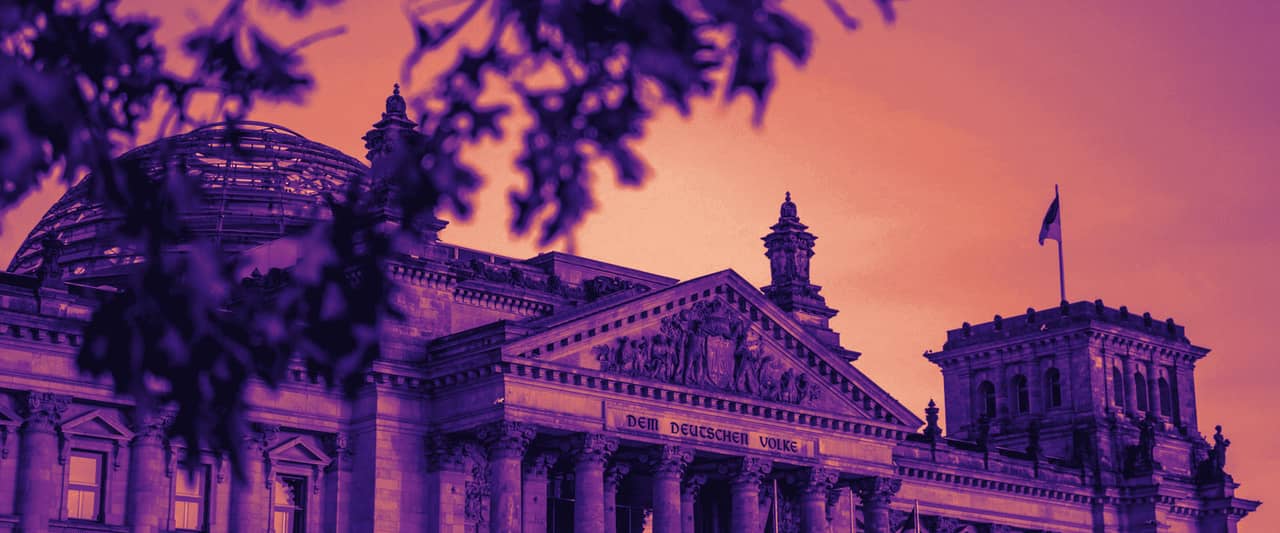 The Reichstag building in Berlin seen through bare branches on a clear day