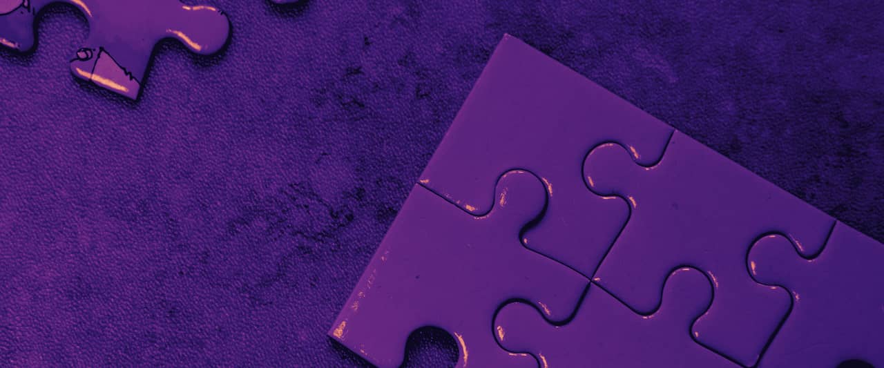 Pale blue jigsaw pieces scattered on a marble table