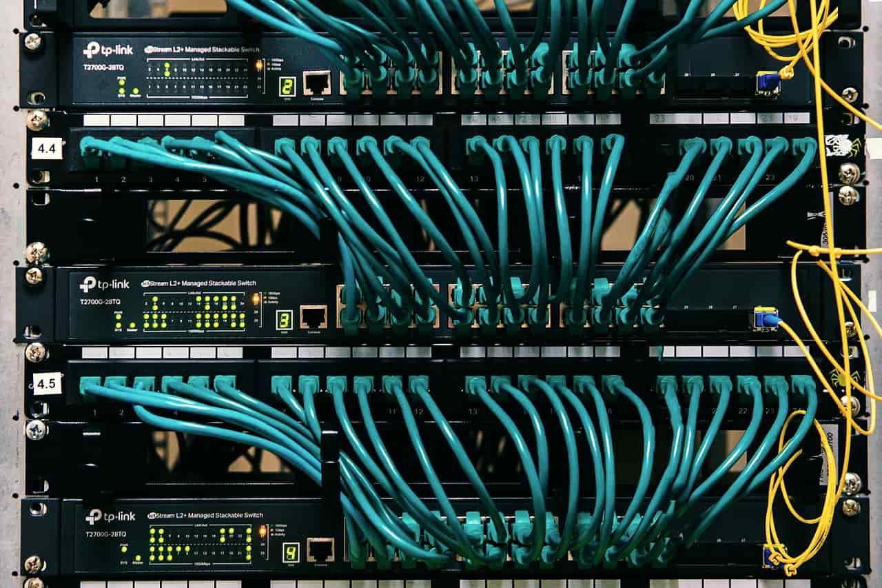 A server rack with rows of teal network cables plugged in