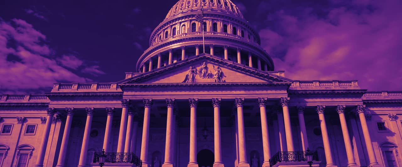 The white dome of the United States Capitol against a blue sky