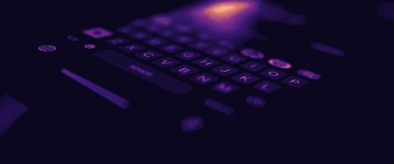The lit keyboard of a phone glowing in a dark room