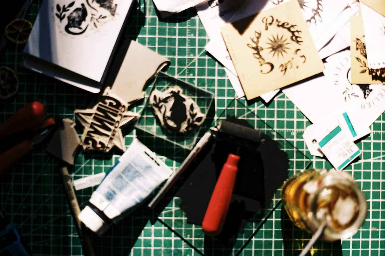 Rubber stamps, ink pads and paper on a green cutting mat
