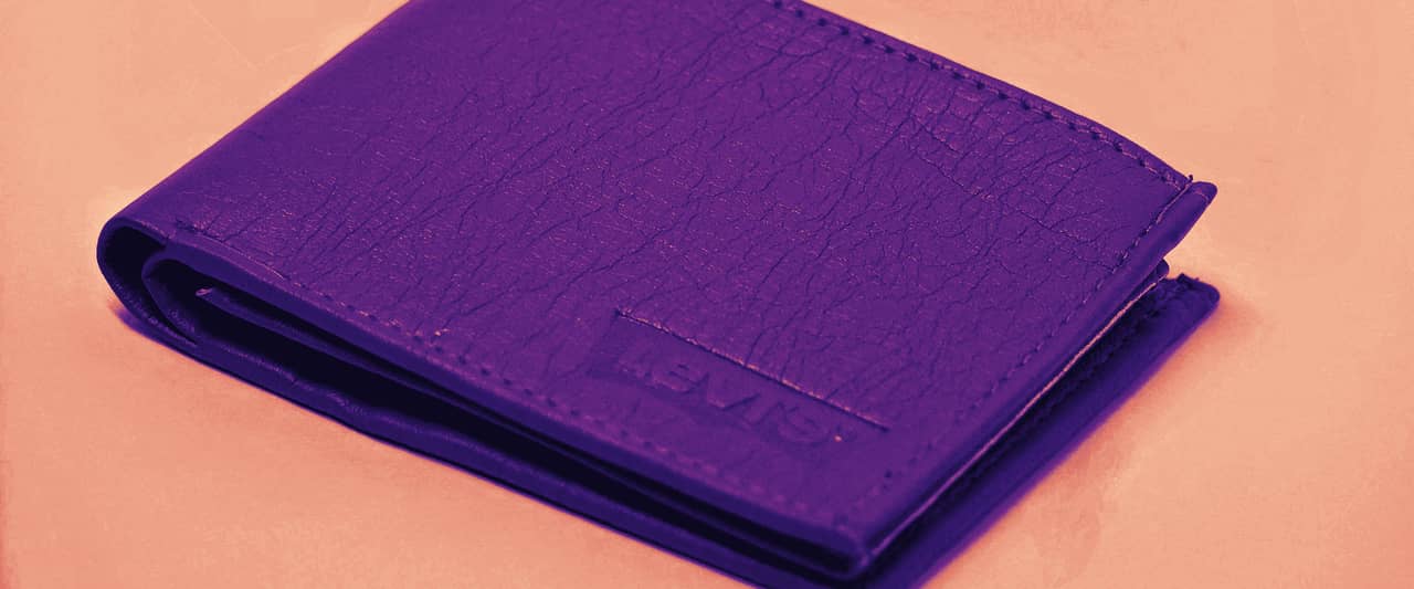 A tan leather bifold wallet on a white table