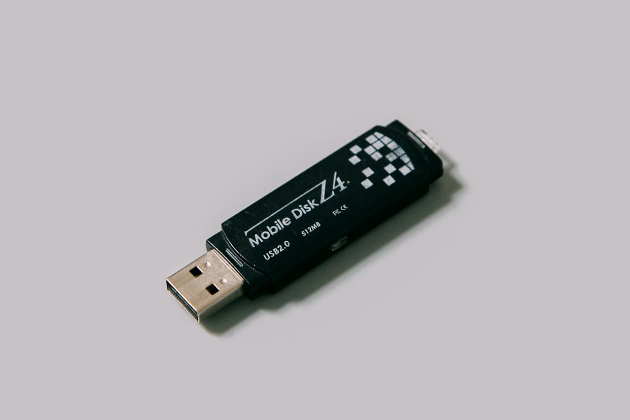 A small black USB drive on a plain grey surface
