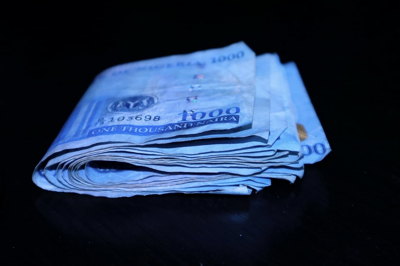 A stack of folded banknotes on a dark surface