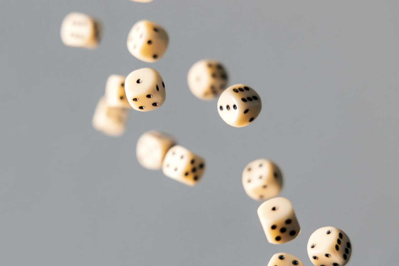 White dice tumbling through the air against a grey background