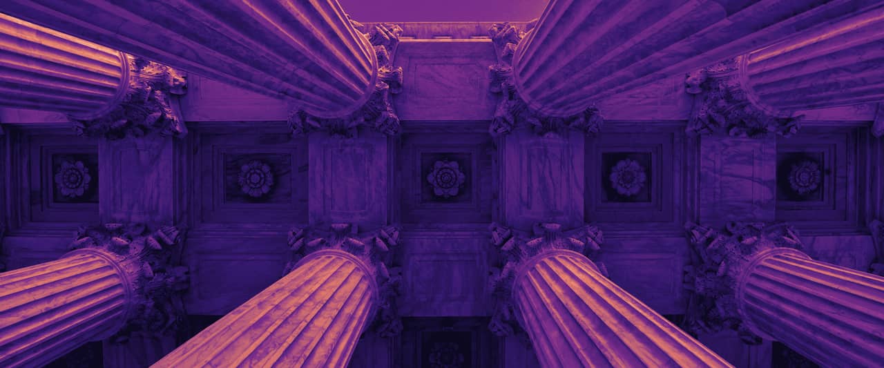 Tall stone columns of a classical building seen from directly below