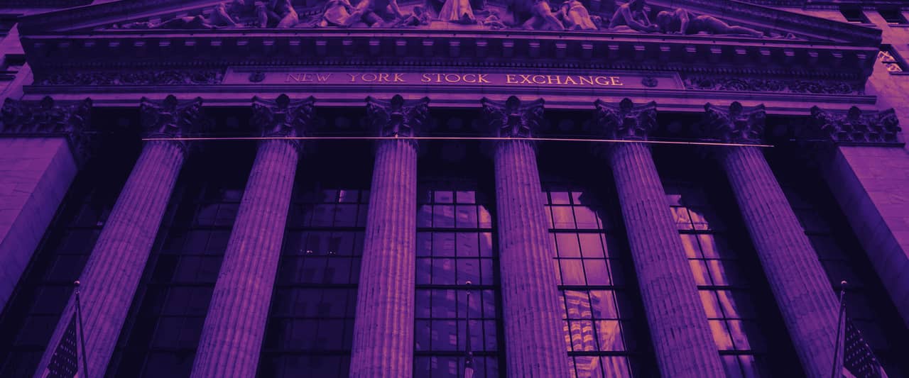 The columned facade of the New York Stock Exchange hung with American flags