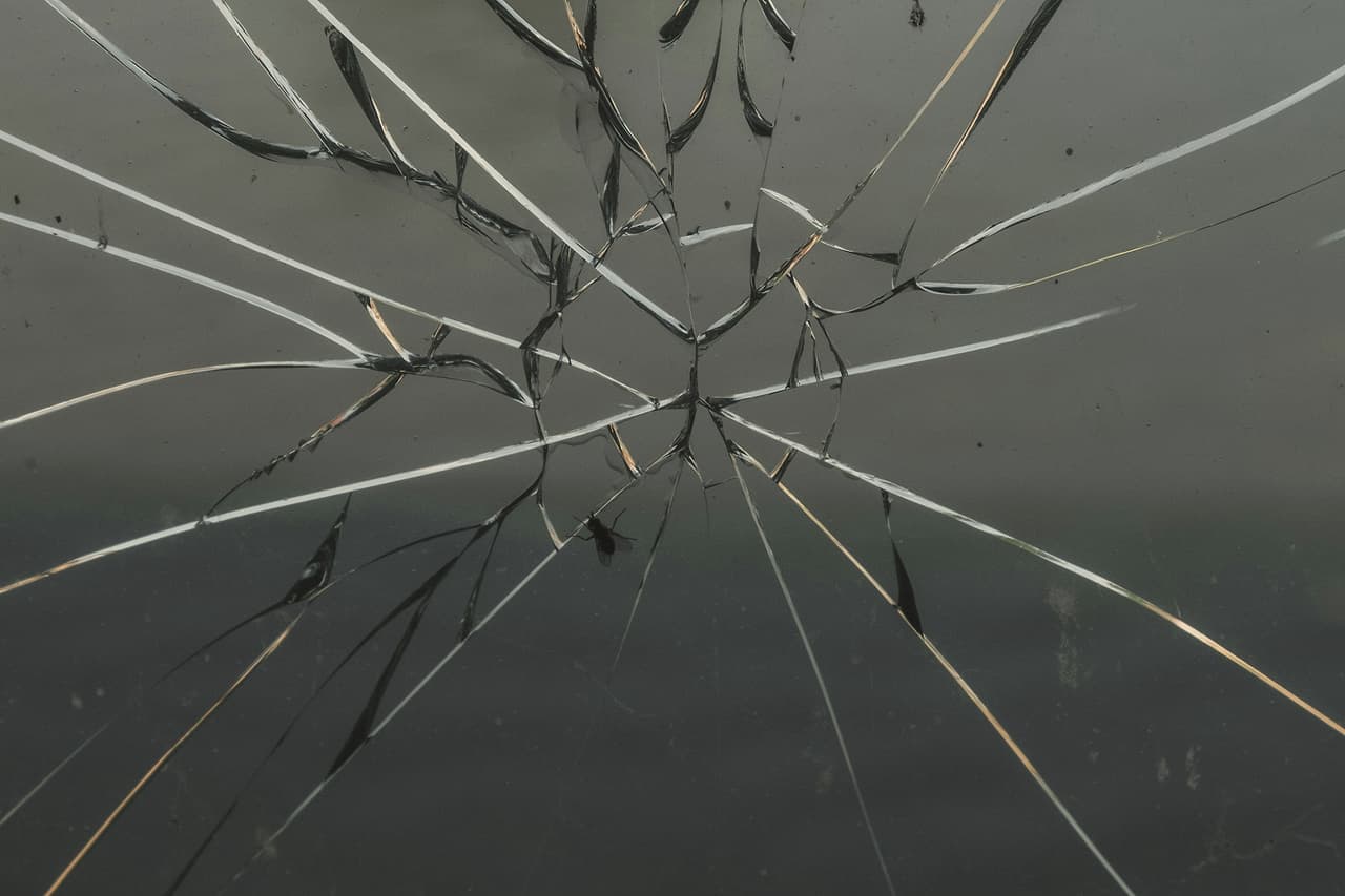A pane of glass cracked in lines spreading from one point