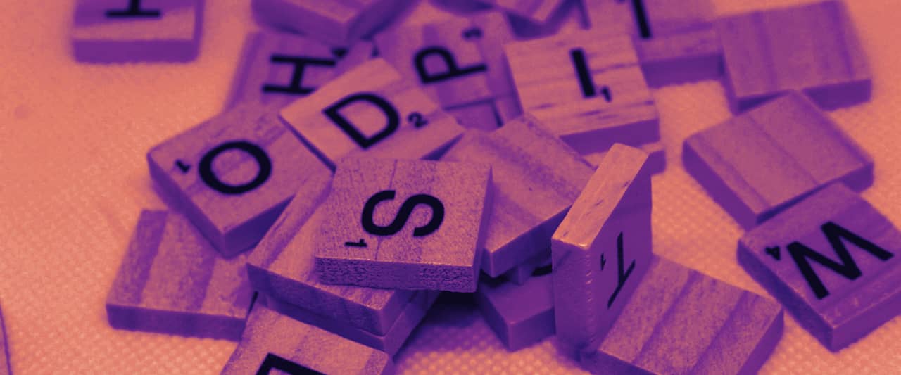 Wooden letter tiles scattered across a white surface