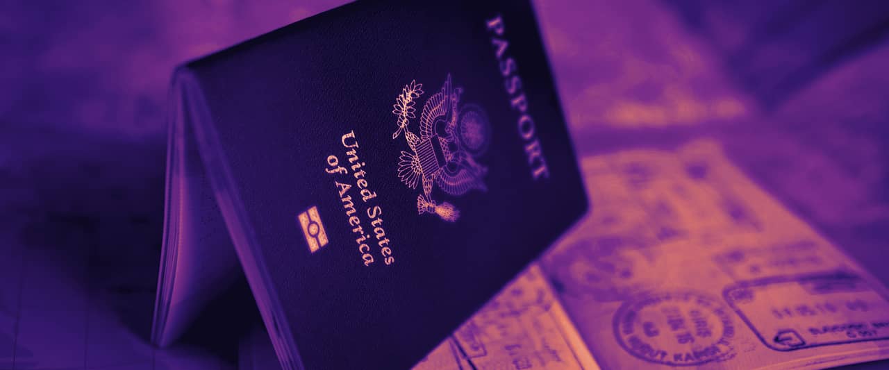 An open United States passport resting on a colourful world map
