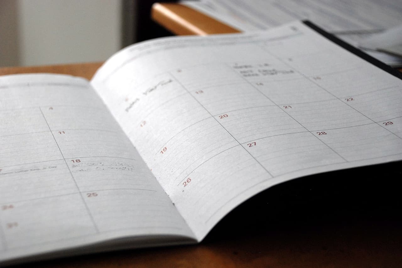 An open monthly planner on a wooden desk