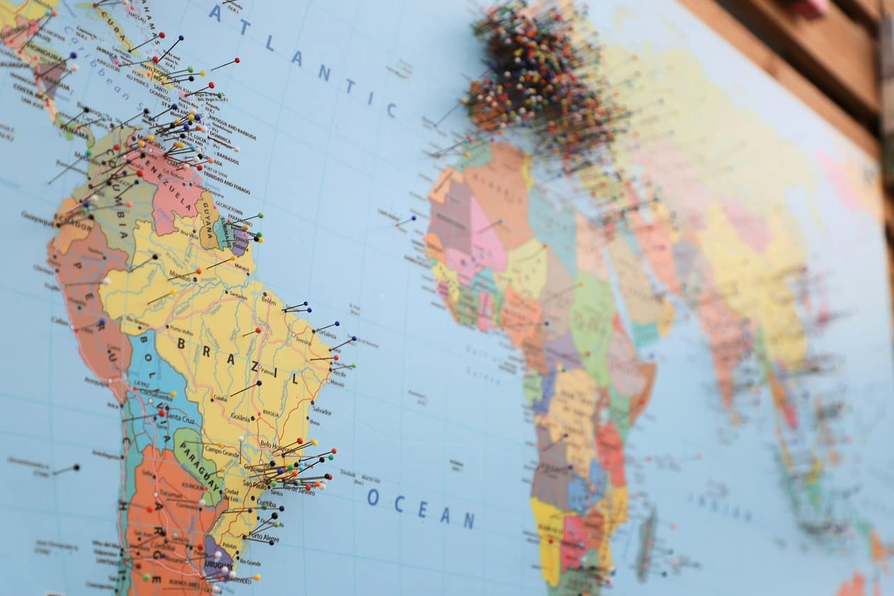 A world map with pins stuck into several countries